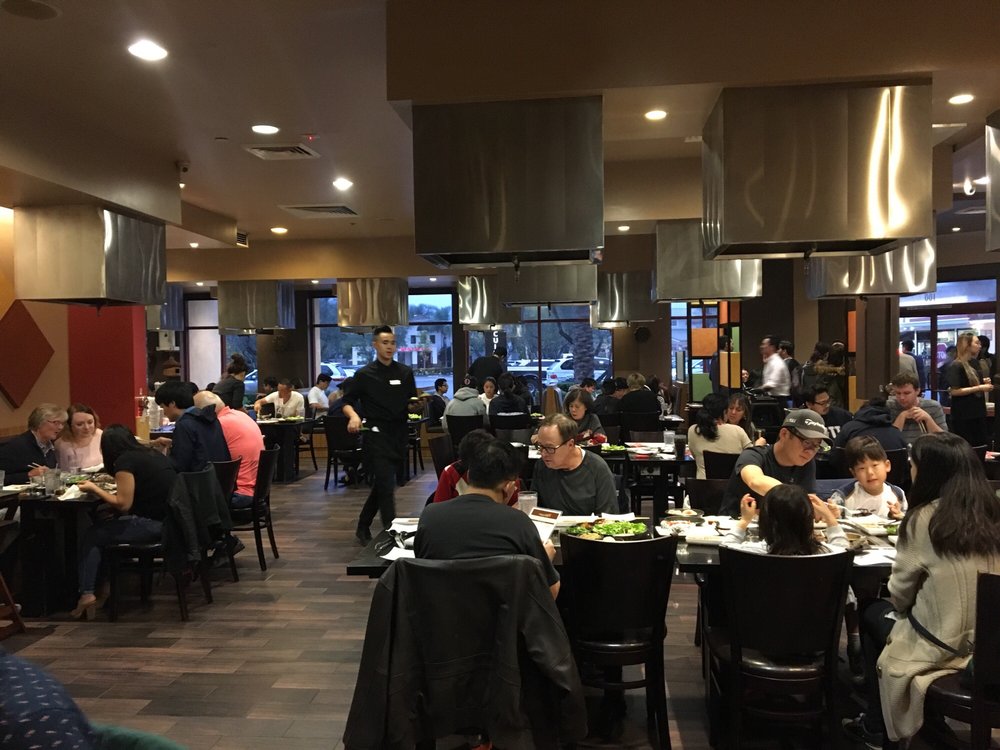 Customers grilling meat tableside at All That Barbecue in Irvine